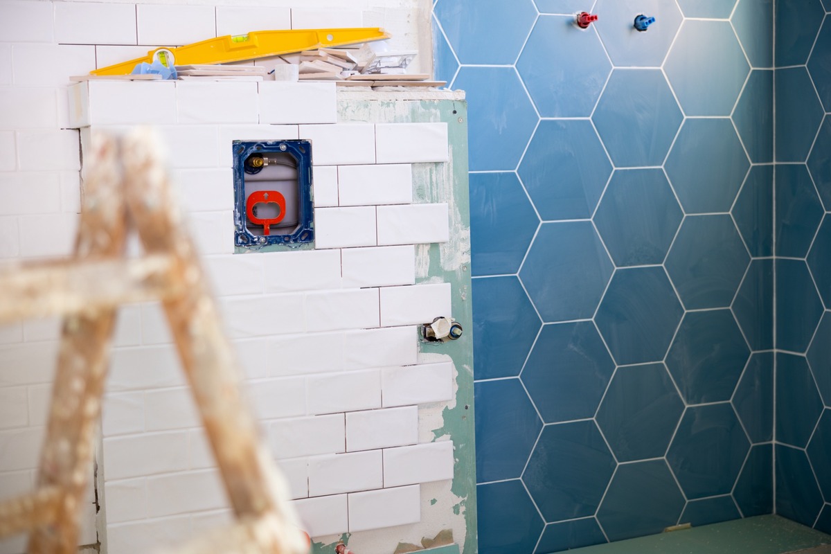 cuarto de baño en proceso de reforma con azulejos blancos